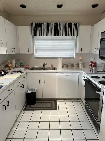 a kitchen with a sink a stove and cabinets