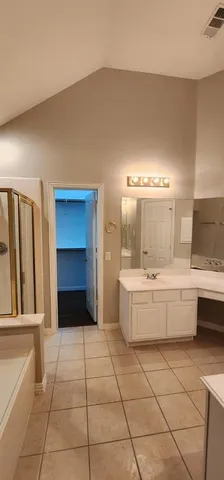 a large bathroom with a tub a sink and a large mirror