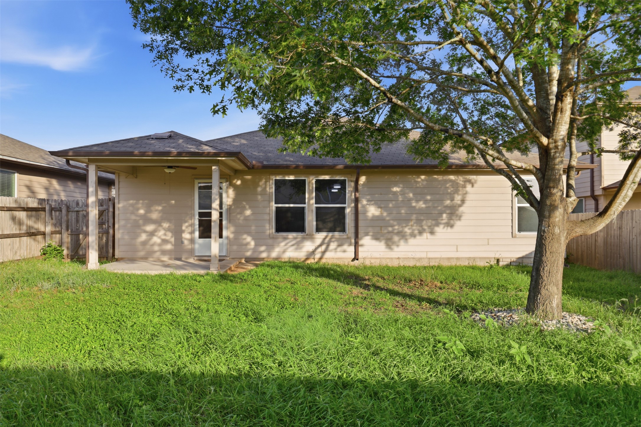448 Nottingham Loop Kyle, TX 78640 - Photo 16 of 16 Expansive backyard featuring a covered patio, mature tree, and a full privacy fence