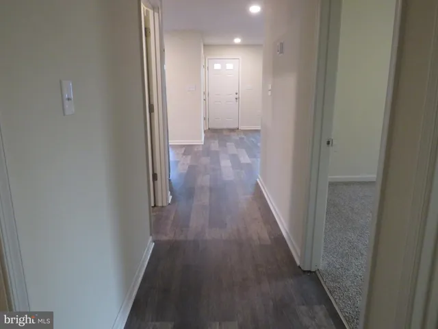 a view of a hallway with wooden floor