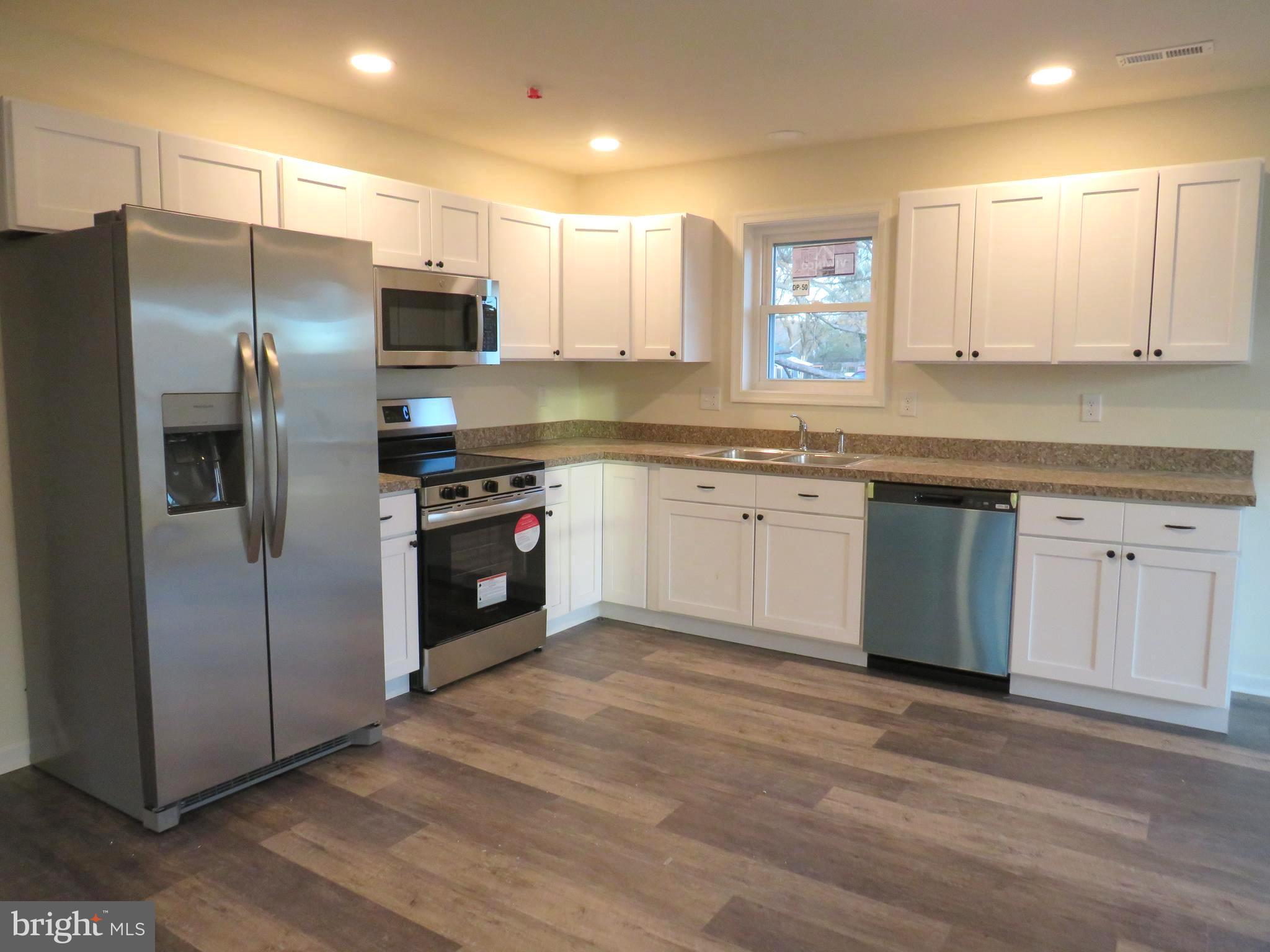 26350 East Pear Street Crisfield, MD 21817 - Photo 8 of 22 a kitchen with stainless steel appliances granite countertop a refrigerator a sink a stove and cabinets