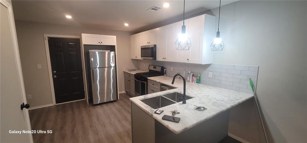 1009 Fairburn Road Northwest Atlanta, GA 30331 - Photo 6 of 15 a kitchen with stainless steel appliances granite countertop a refrigerator a sink a stove and a refrigerator with wooden floor