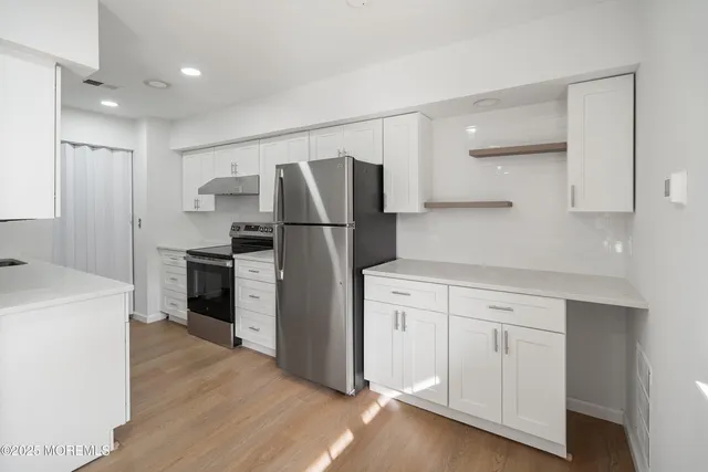 a kitchen with white cabinets and stainless steel appliances