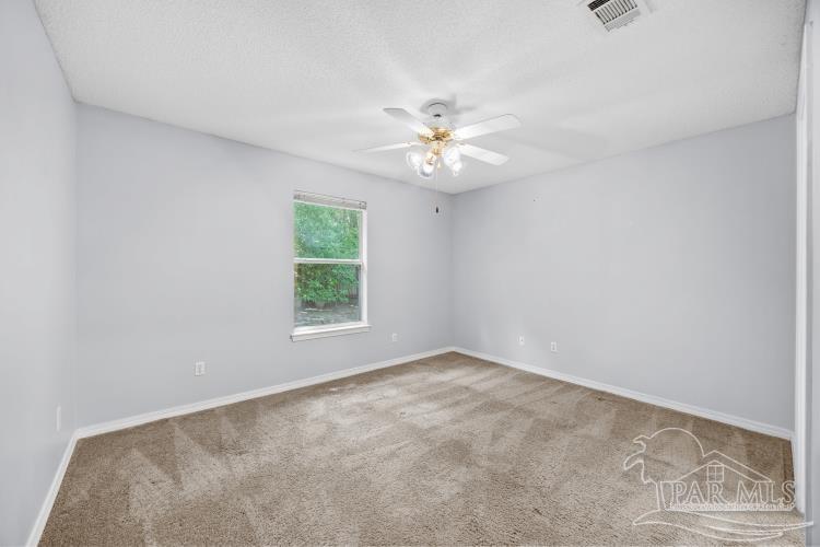 1009 Simpson Street Pensacola, FL 32526 - Photo 14 of 18 an empty room with a window and a fan