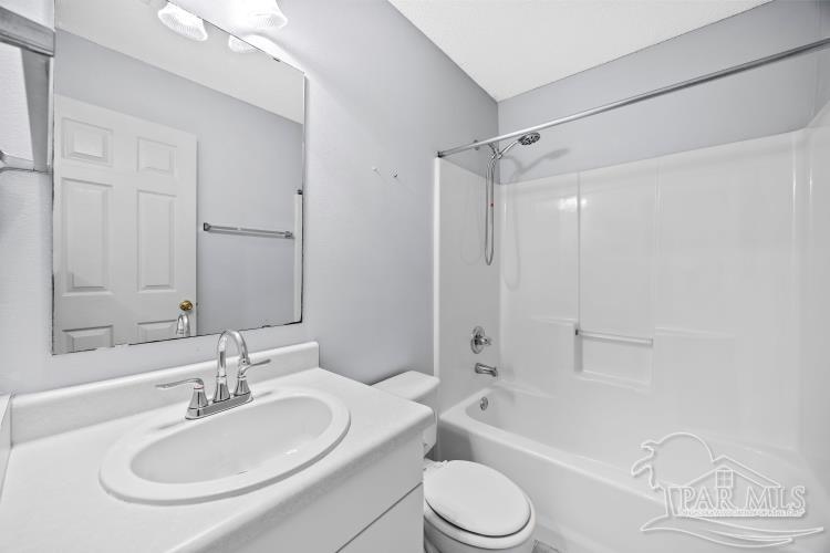 1009 Simpson Street Pensacola, FL 32526 - Photo 15 of 18 a bathroom with a bathtub shower sink mirror vanity and a toilet