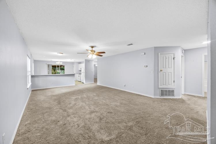 1009 Simpson Street Pensacola, FL 32526 - Photo 3 of 18 a view of a big room with windows and chandelier fan