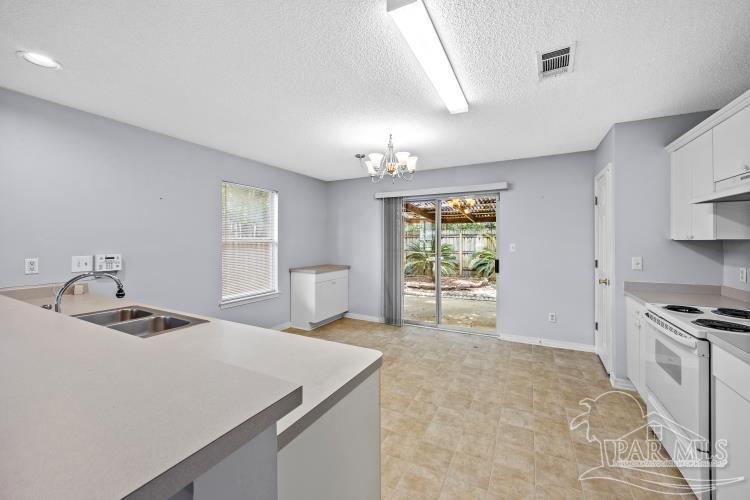 1009 Simpson Street Pensacola, FL 32526 - Photo 6 of 18 a kitchen that has a sink a stove and chairs