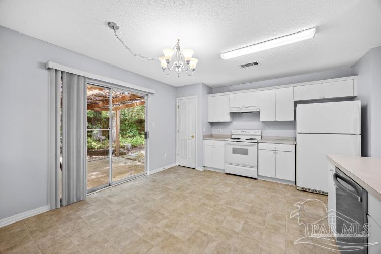 1009 Simpson Street Pensacola, FL 32526 - Photo 7 of 18 a kitchen with white cabinets and white appliances