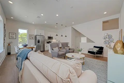 a living room with furniture and a refrigerator