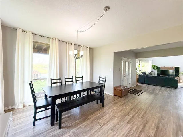 a living room with furniture a large window and wooden floor