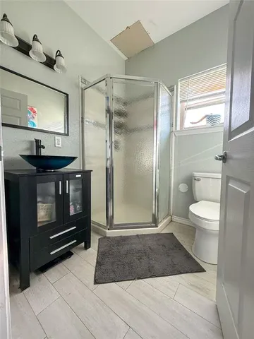a bathroom with a sink a toilet a mirror and shower