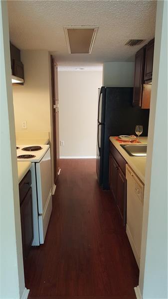 4541 West McNab Road, Unit 26 Pompano Beach, FL 33069 - Photo 6 of 12 a kitchen with a refrigerator and a stove top oven