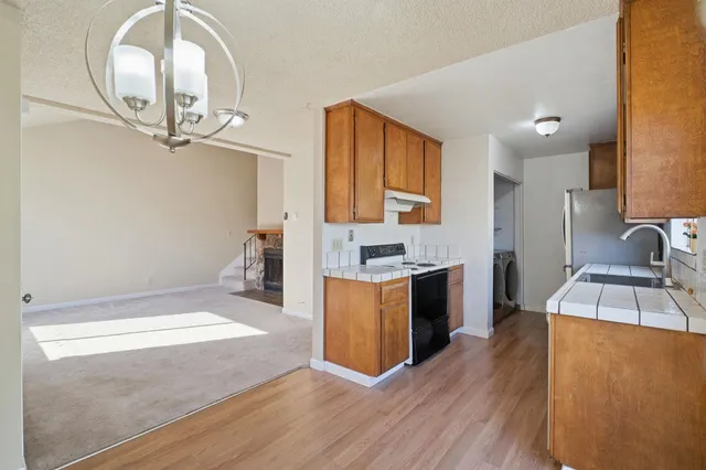 a large kitchen with stainless steel appliances a large counter top a stove and a sink