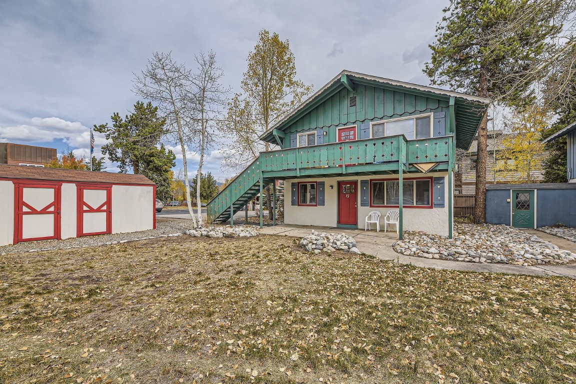 a view of a white house with a large tree and a yard
