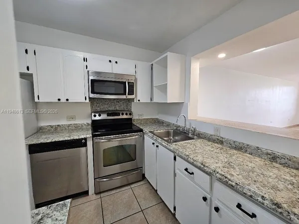 a kitchen with granite countertop a sink and a stove top oven