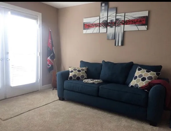 a view of a workspace with furniture and a window