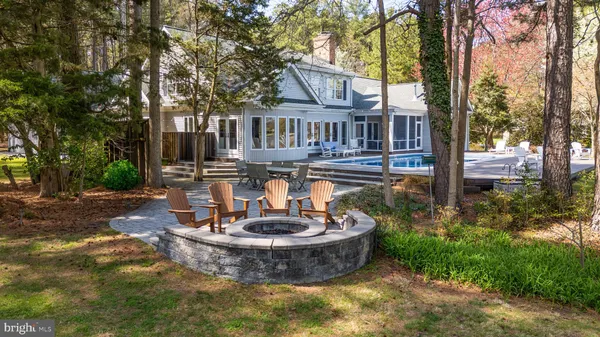 a kitchen with stainless steel appliances granite countertop a stove a refrigerator a kitchen island a dining table and chairs with wooden floor