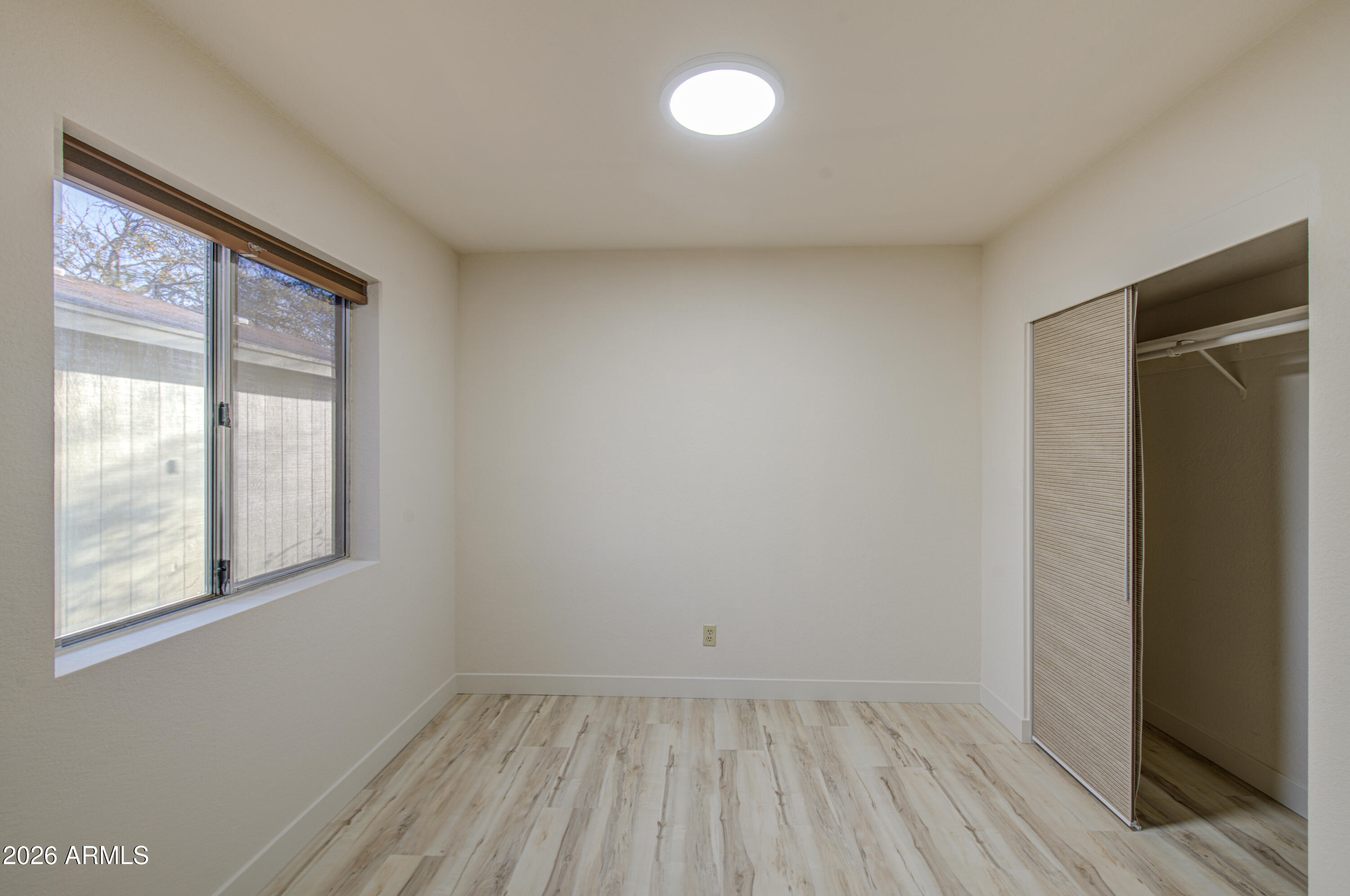 1350 North Boyd Road Apache Junction, AZ 85119 - Photo 20 of 31 a view of an empty room with wooden floor and a window