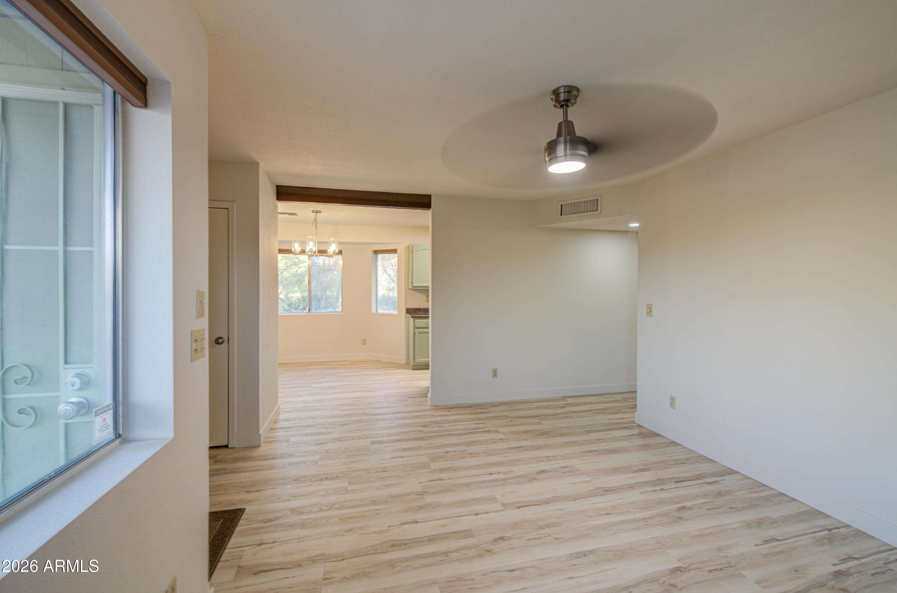 1350 North Boyd Road Apache Junction, AZ 85119 - Photo 5 of 31 a view of an empty room with wooden floor and a window