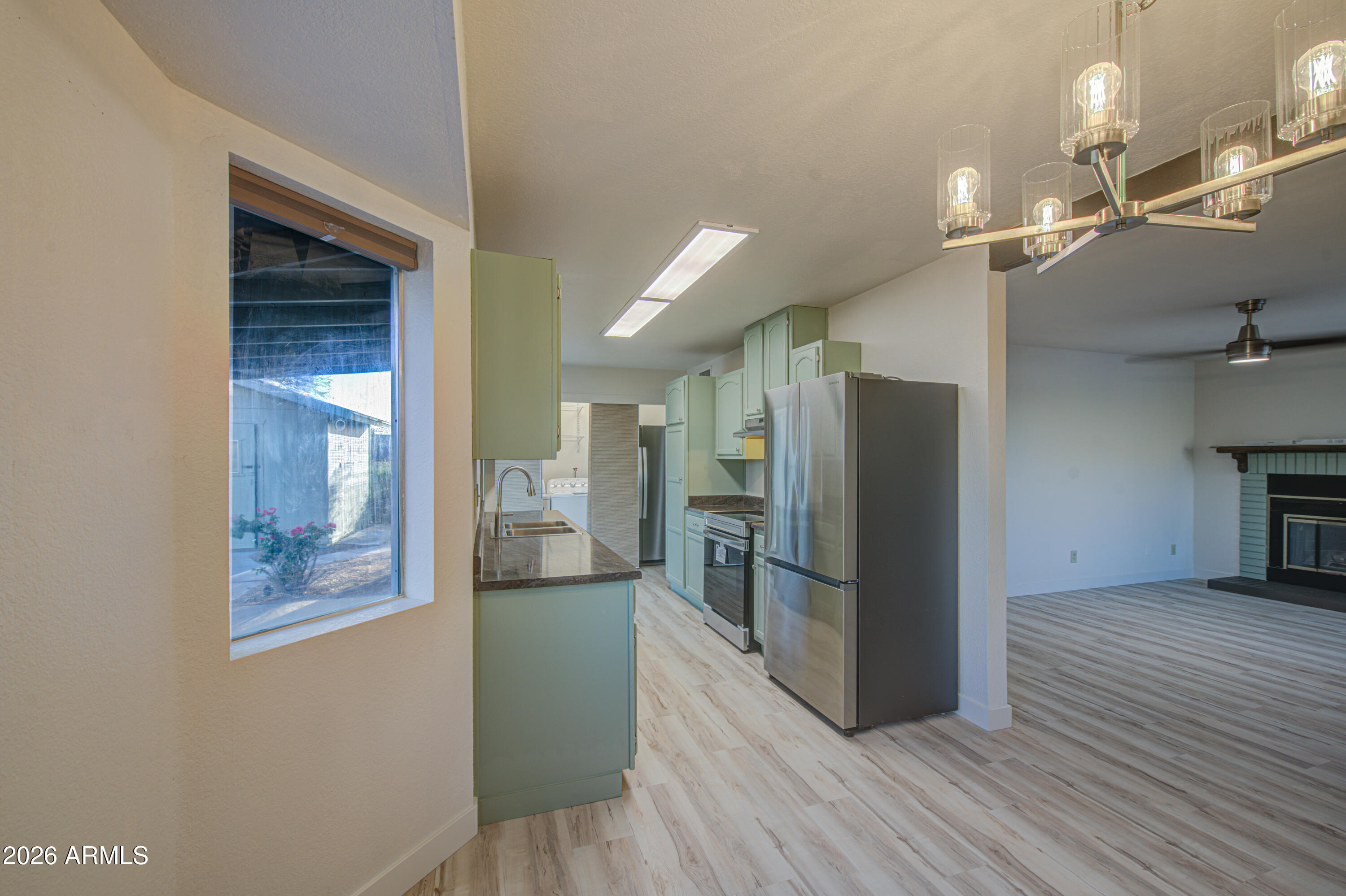 1350 North Boyd Road Apache Junction, AZ 85119 - Photo 8 of 31 a view of a refrigerator in kitchen and wooden floor