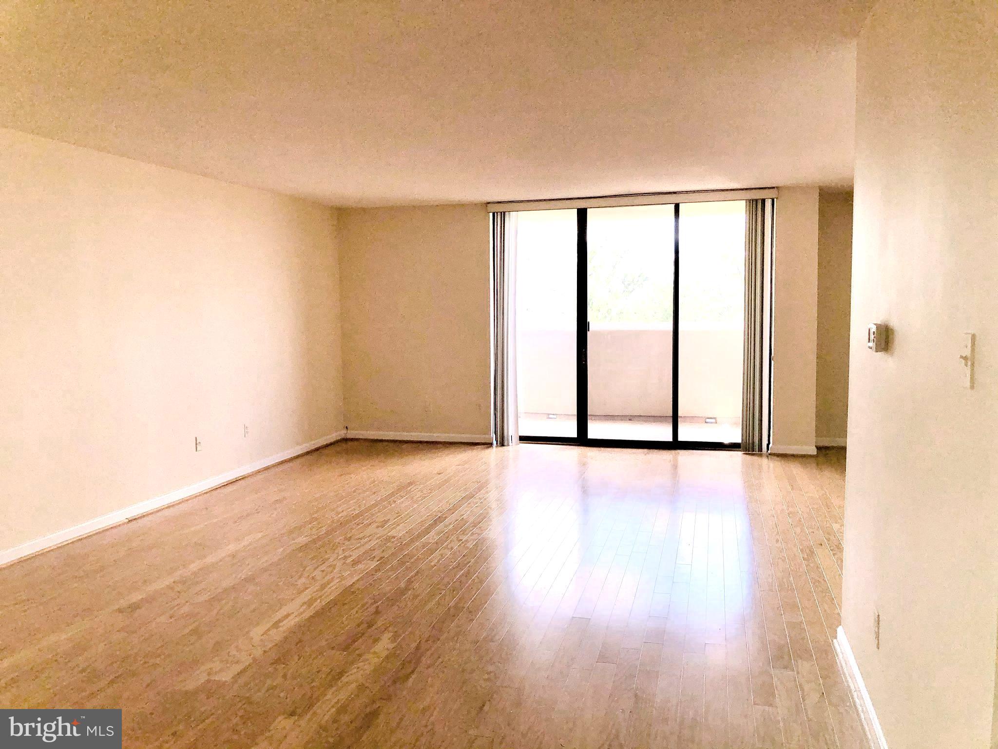 1101 South Arlington Ridge Road, Unit 704 Arlington, VA 22202 - Photo 12 of 37 an empty room with wooden floor and windows