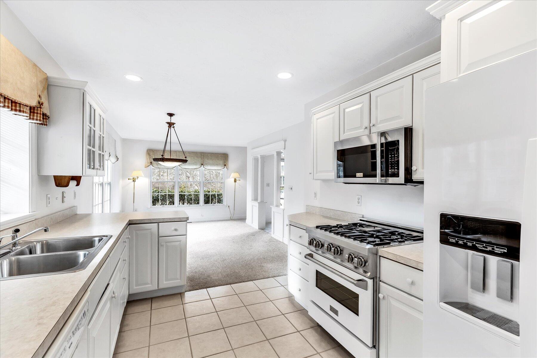14 Bishops Park Mashpee, MA 02649 - Photo 11 of 42 a kitchen with stainless steel appliances a sink stove top oven and cabinets