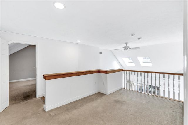 an empty room with a chandelier fan and a window