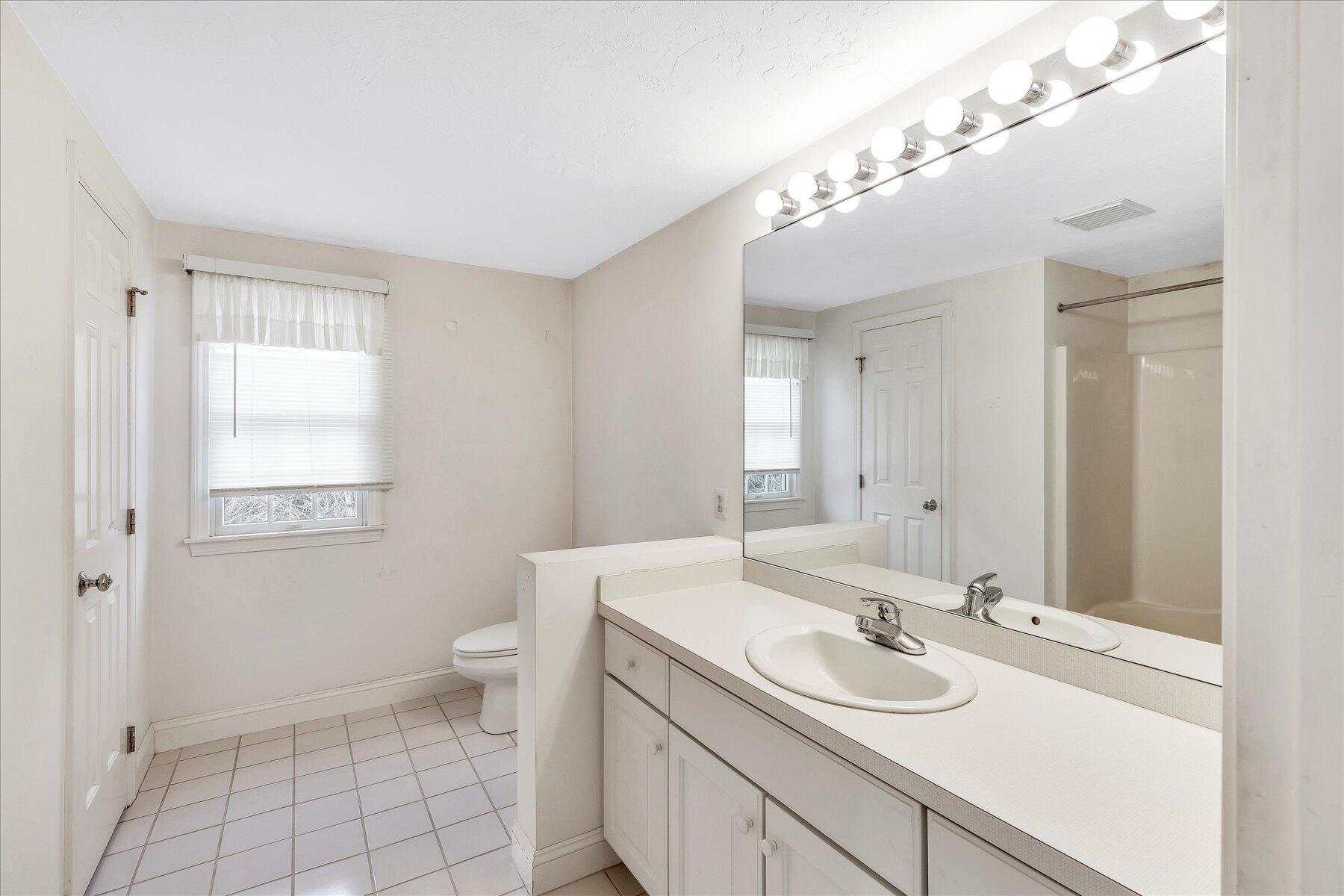 14 Bishops Park Mashpee, MA 02649 - Photo 33 of 42 a bathroom with a sink a toilet and a mirror