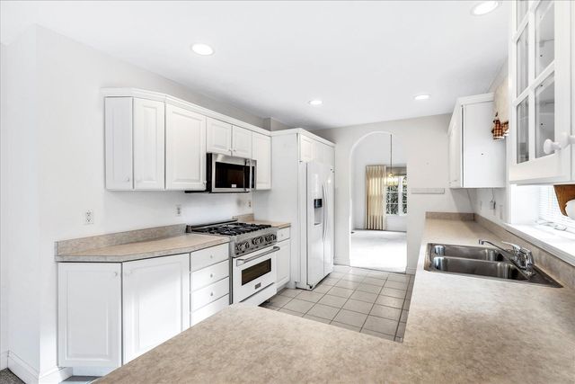 a kitchen with stainless steel appliances a sink stove top oven and cabinets
