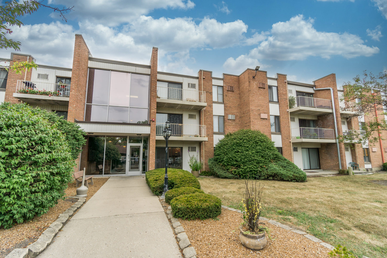 300 West Fullerton Avenue, Unit 305 Addison, IL 60101 - Photo 1 of 18 a front view of a residential apartment building with a yard