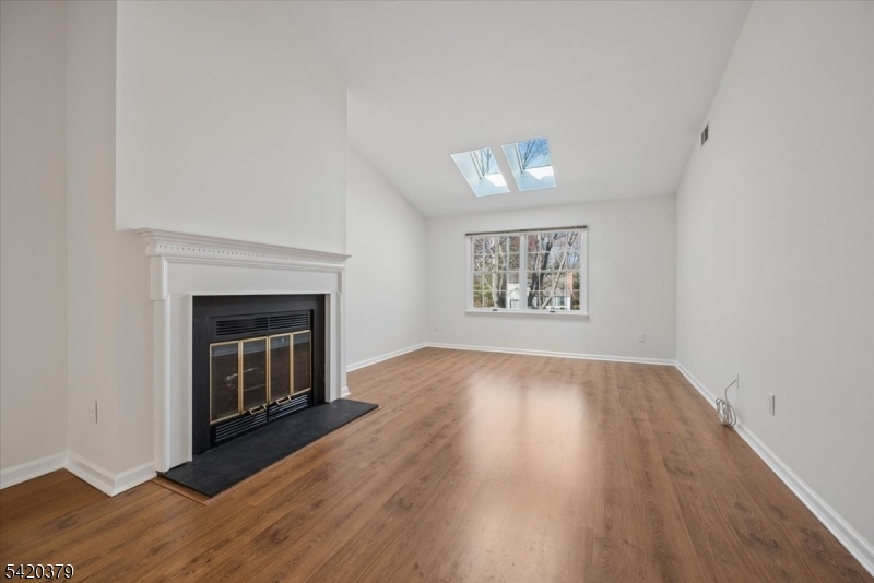20 Alexandria Way Bernards, NJ 07920 - Photo 6 of 26 an empty room with wooden floor a fireplace and windows