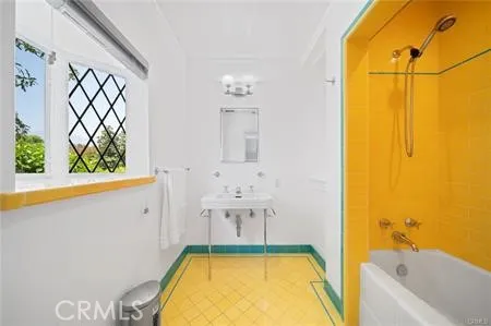 a bathroom with a tub sink and mirror