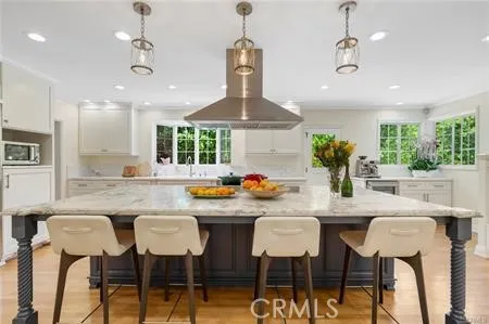 a kitchen with stainless steel appliances a dining table chairs and white cabinets