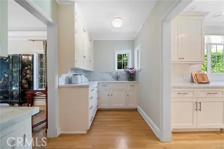 a kitchen with white cabinets and sink