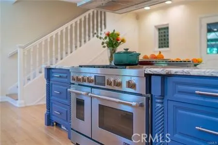 a kitchen with granite countertop a stove and a wooden floors