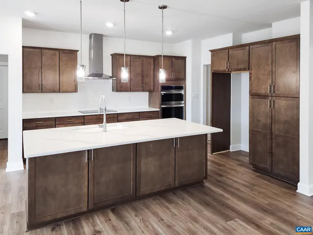 a large kitchen with stainless steel appliances a sink and a refrigerator