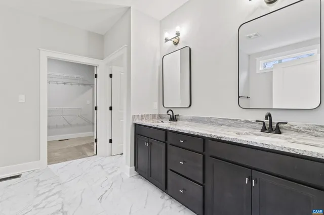 a bathroom with double vanity sinks and a shower