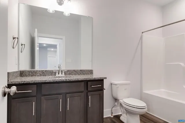 a bathroom with a granite countertop sink toilet and a mirror