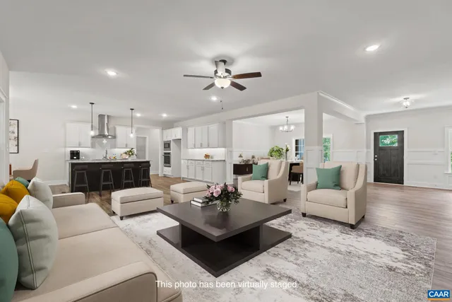 a living room with furniture kitchen view and a chandelier