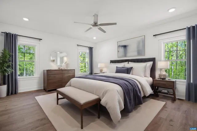 a bedroom with a large bed a chandelier and windows