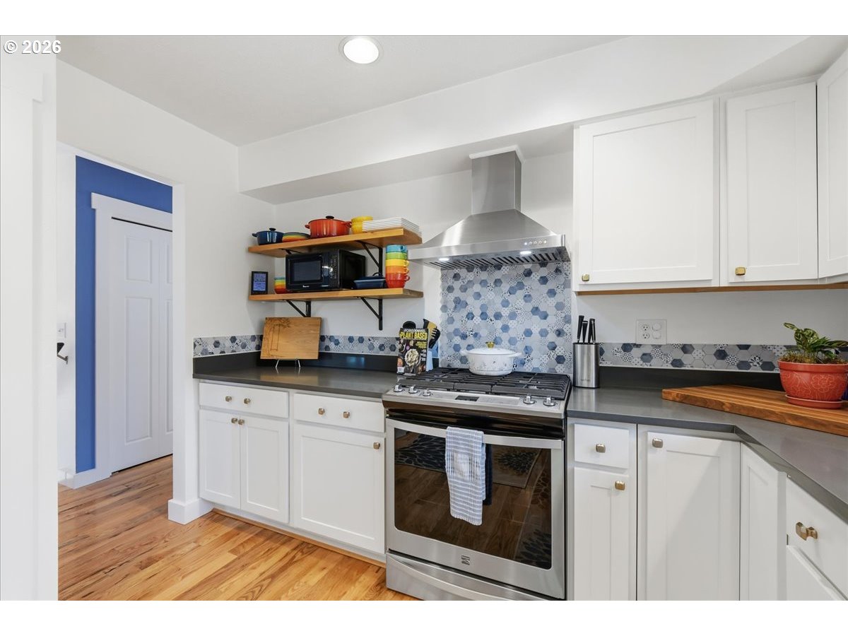 10339 Southwest 40th Avenue Portland, OR 97219 - Photo 13 of 37 a kitchen with stainless steel appliances granite countertop a stove a sink and a microwave