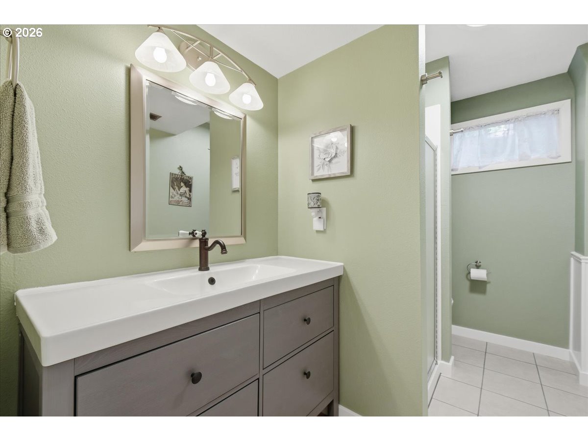 10339 Southwest 40th Avenue Portland, OR 97219 - Photo 26 of 37 a bathroom with a sink a mirror and a shower