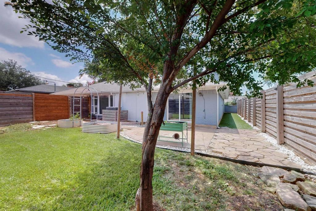 4857 Fallon Place Dallas, TX 75227 - Photo 18 of 19 Back of property with a fenced backyard, a patio area, and brick siding