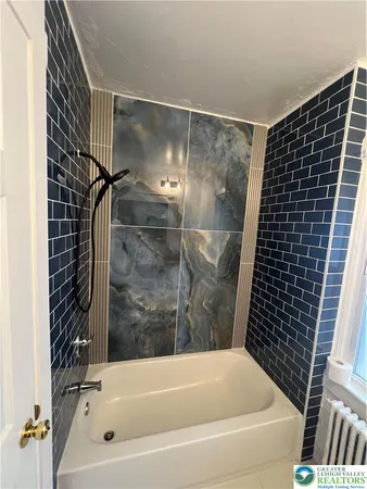 a bathroom with a bathtub and shower