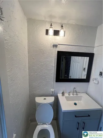 a bathroom with a sink toilet and mirror