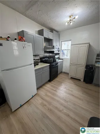a kitchen with a refrigerator and a stove top oven