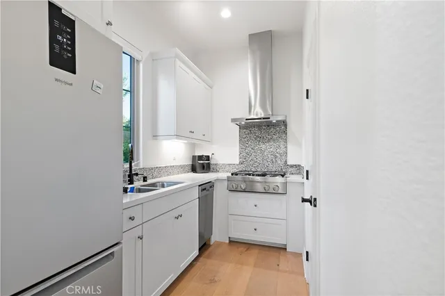 a kitchen with a sink cabinets stainless steel appliances and a window