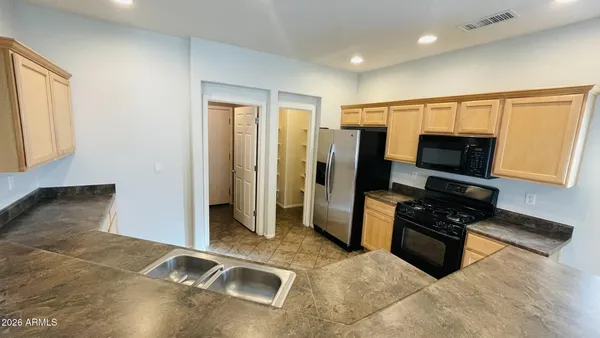 a kitchen with granite countertop a refrigerator and a sink