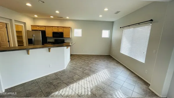 a view of kitchen with stainless steel appliances wooden floor and window
