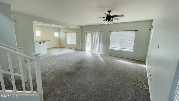 an empty room with a ceiling fan and a window